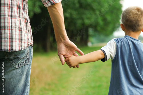 the parent holds the hand of a l child