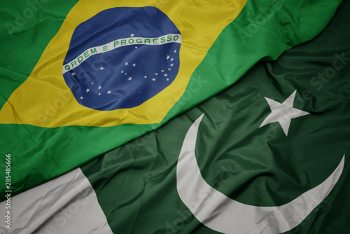 waving colorful flag of pakistan and national flag of brazil.