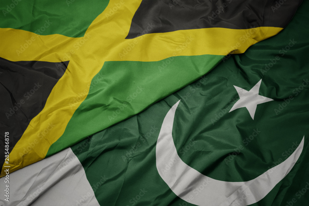 waving colorful flag of pakistan and national flag of jamaica. waving colorful flag of pakistan and national flag of jamaica.