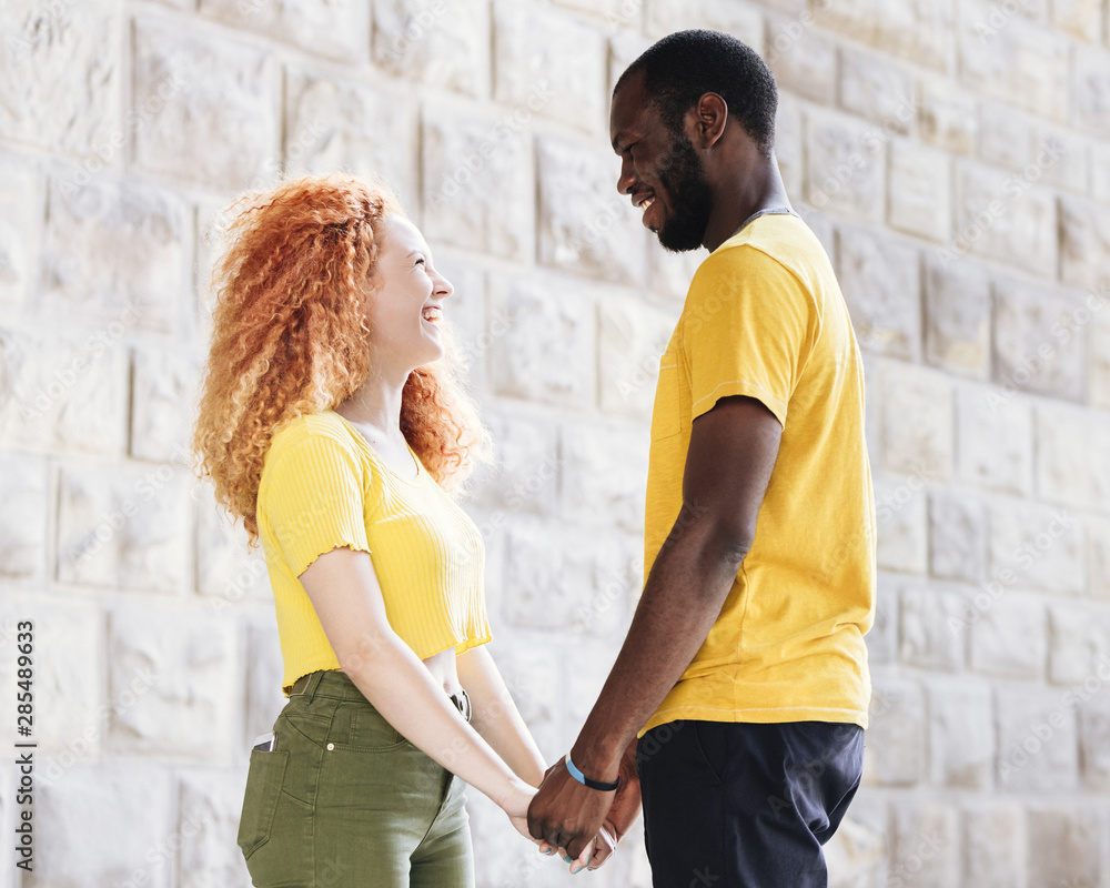 Side view of interracial couple holding hands