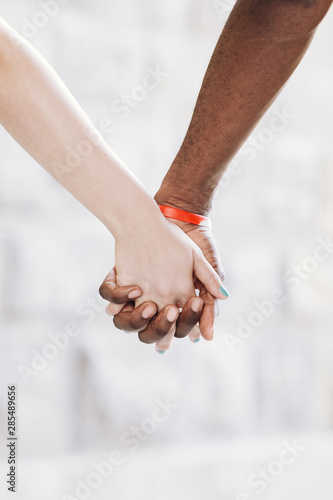 Close-up of interracial couple holding hands