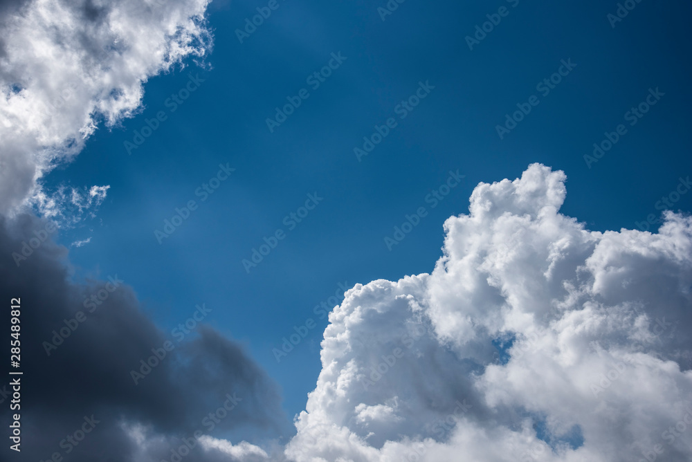 Beautiful white and dark clouds on the blue sky with sun beams Beautiful white and dark clouds on the blue sky with sun beams