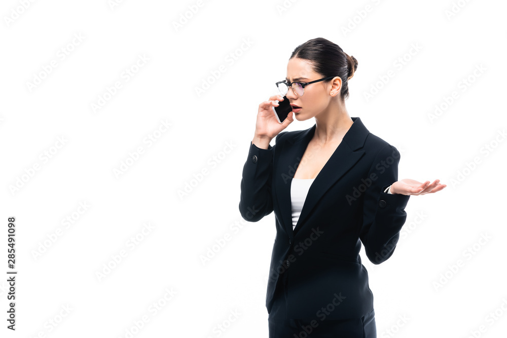 dissatisfied businesswoman gesturing while talking on smartphone isolated on white