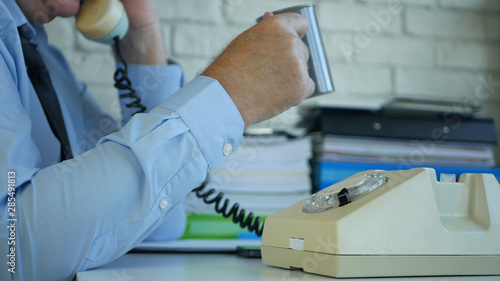 Image with Businessman in Office Talking on Telephone and Drinking Coffee