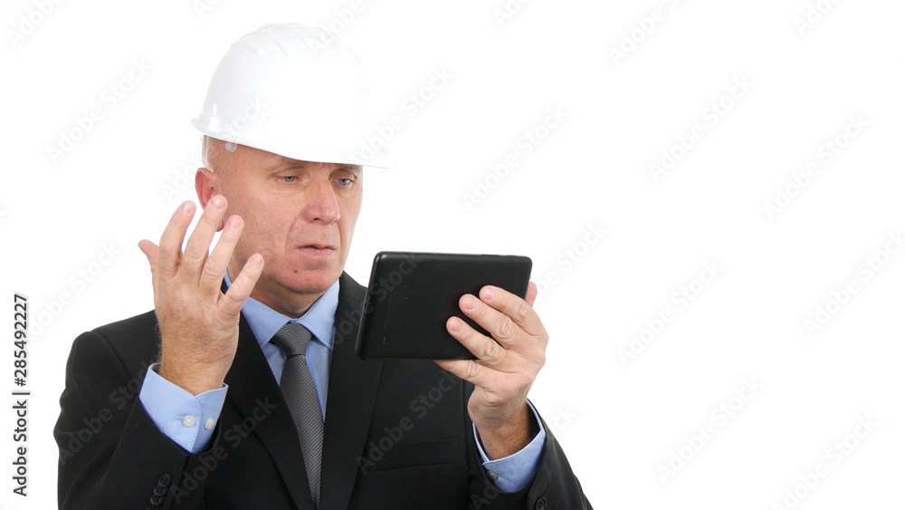Image with Worried Businessman Wearing Hardhat and Using Electronic Tablet Image with Worried Businessman Wearing Hardhat and Using Electronic Tablet