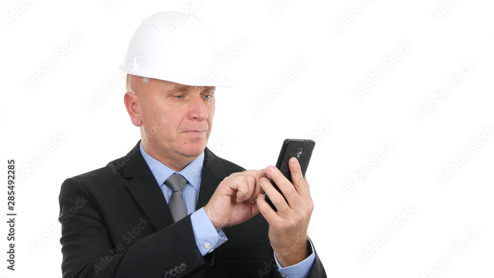 Image with Businessman Wearing Helmet and Texting Using Cellphone Communication Image with Businessman Wearing Helmet and Texting Using Cellphone Communication