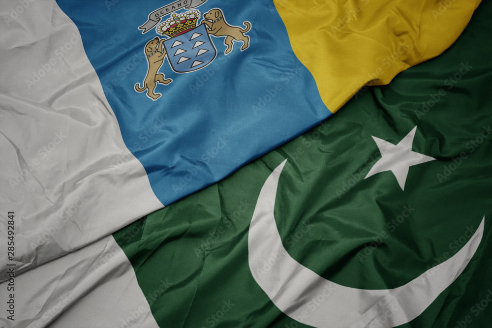 waving colorful flag of pakistan and national flag of canary islands. waving colorful flag of pakistan and national flag of canary islands.