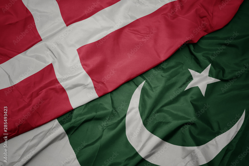 waving colorful flag of pakistan and national flag of denmark.