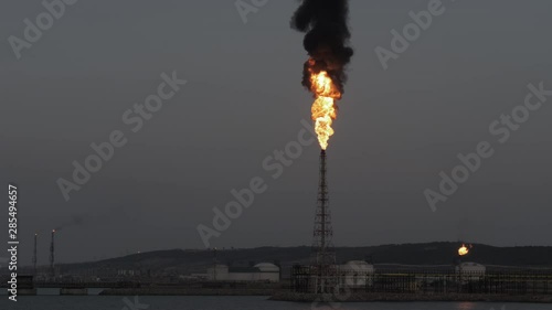 Gas flare and smoke of petrochemical refinery in twilight