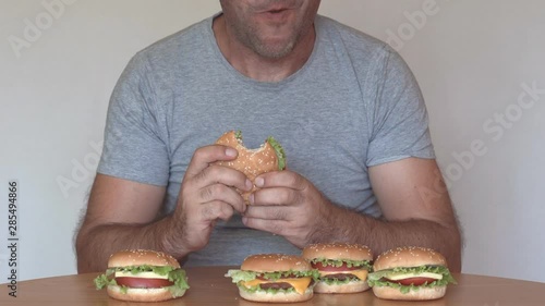 Hungry man eating fast food hamburger. Unhealthy eating