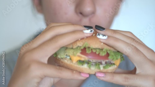 Hungry teenage girl eating burger, Unhealthy eating. Close up