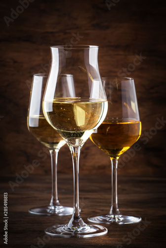 White wine set. Wine tasting, the most popular varieties of white wines in wine glasses on vintage wooden table in rustic style, selective focus