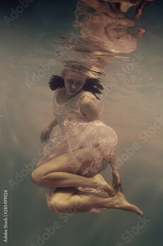 Portrait of a girl in a dress under water