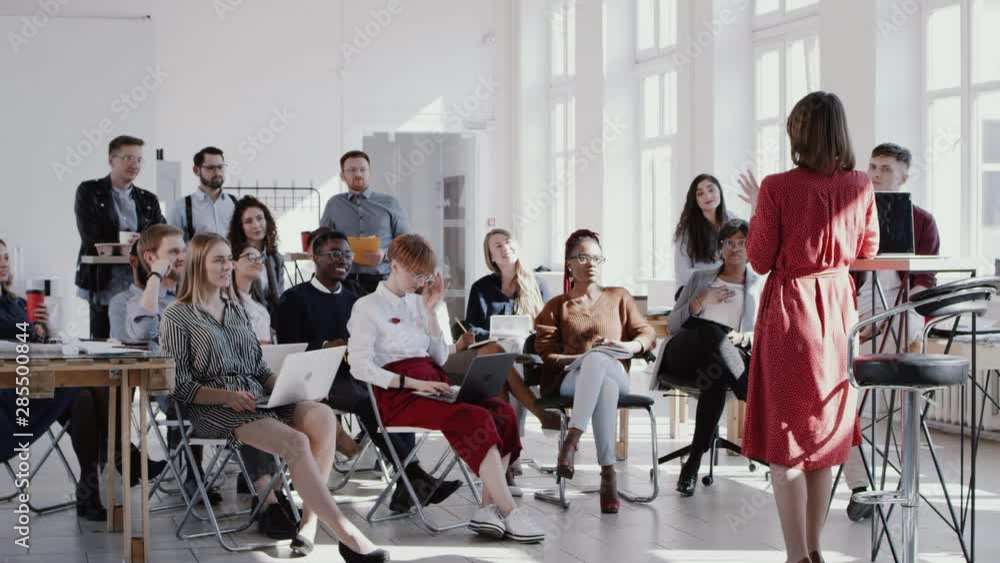 RED EPIC Happy middle aged female coach giving speech at modern office seminar event for multiethnic team slow motion. RED EPIC Happy middle aged female coach giving speech at modern office seminar event for multiethnic team slow motion.