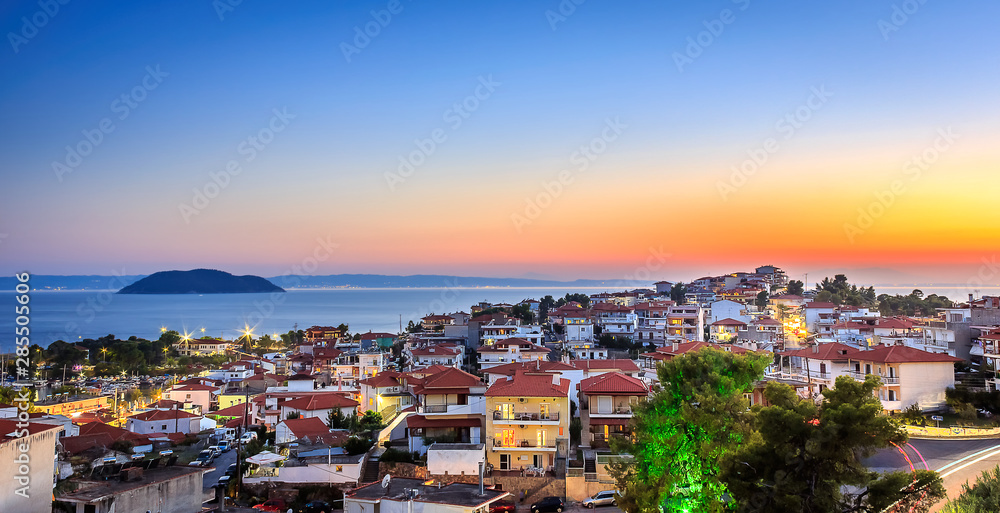 Late golden hour view of amazing Neos Marmaras cityscape and distant turtle island in Greece