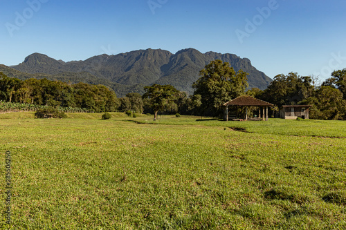 A meadow below a mountain-range on a sunny day