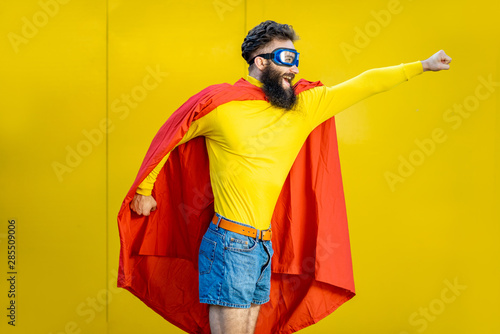 Φωτογραφία Portrait of a man like a superhero in colorful clothes and pilot's glasses on th