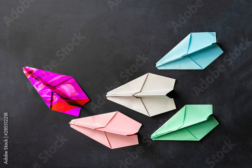 a unique paper plane with some regular ones  leadership concept on the table