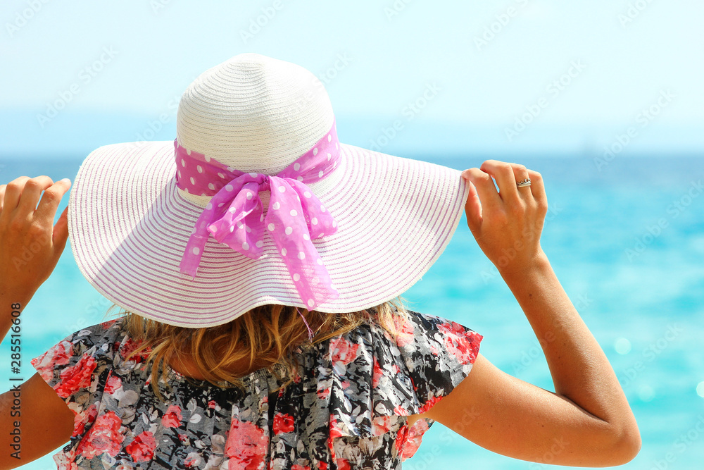 Young woman in a hat on the seashore