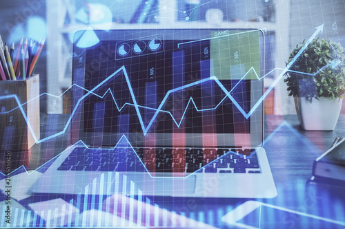 Double exposure of graph and financial info and work space with computer background. Concept of international online trading. © peshkova