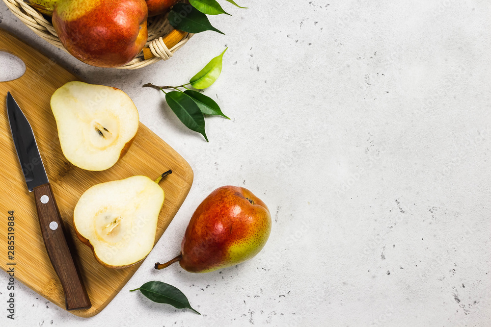 Ripe colourful pears sliced on cutting board. Top view, space for text. Ripe colourful pears sliced on cutting board. Top view, space for text.