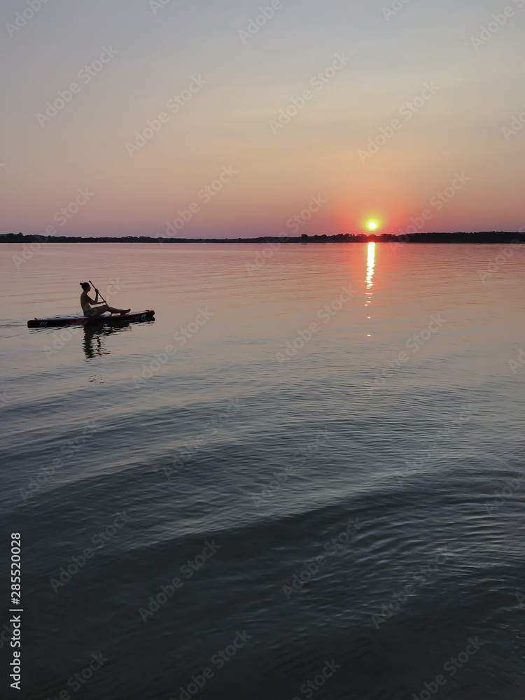 Fototapeta premium Sunset on the water. Evening kayak ride