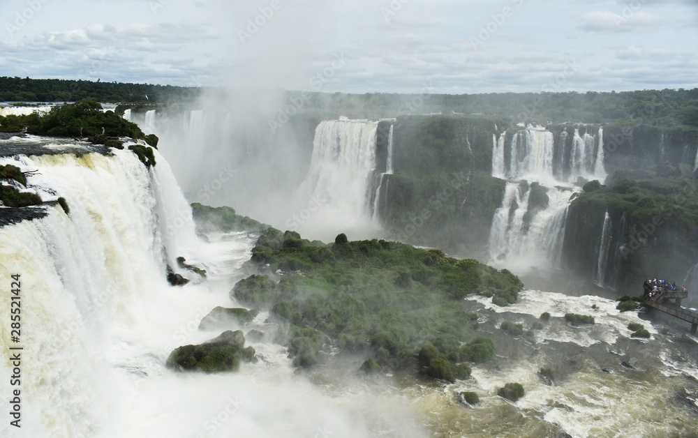 Iguazu Falls or Iguaçu Falls are waterfalls of the Iguazu River on the border of the Argentine and Brazil. Together, they make up the largest waterfall system in the world. Iguazu Falls or Iguaçu Falls are waterfalls of the Iguazu River on the border of the Argentine and Brazil. Together, they make up the largest waterfall system in the world.