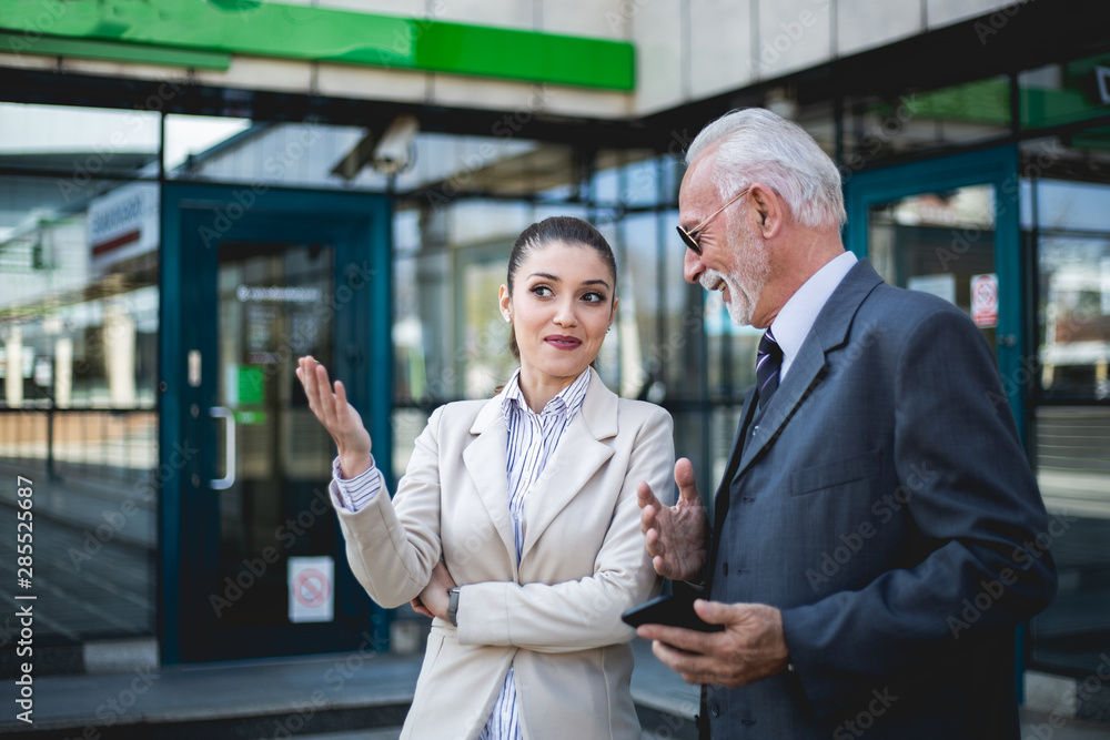 An older man and a young colleague are talking about work An older man and a young colleague are talking about work