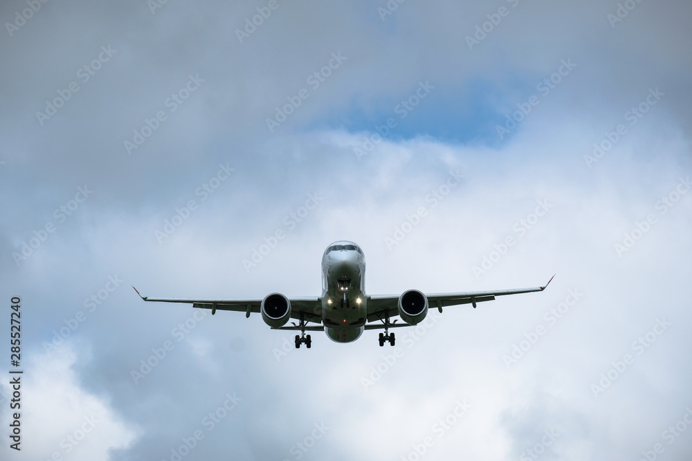 Airplane in landing approach with dark cloudscape Airplane in landing approach with dark cloudscape