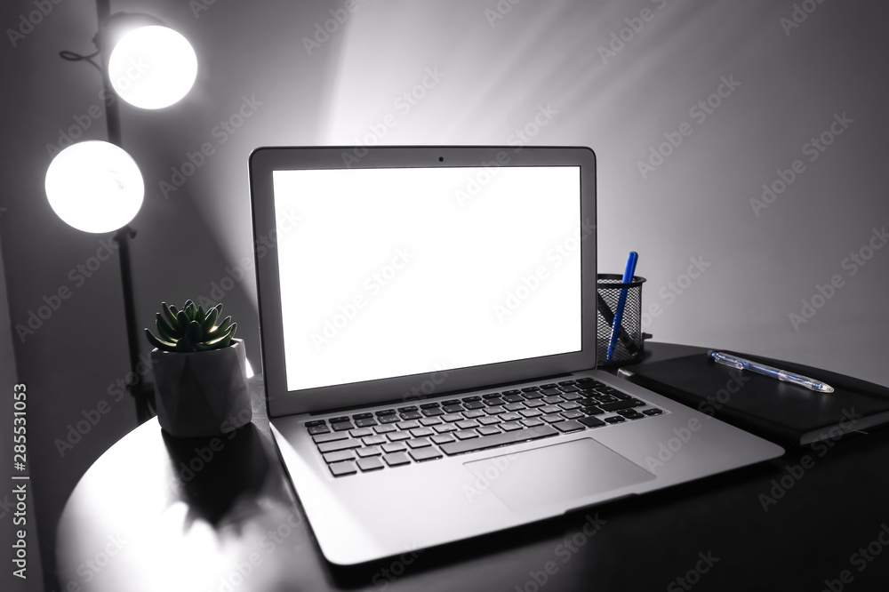 Modern workplace with laptop in evening Modern workplace with laptop in evening