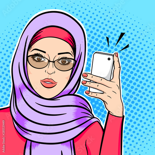 Beautiful muslim woman in hijab holding mobile phone reading sms or taking selfie concept vector in pop art comic retro style.