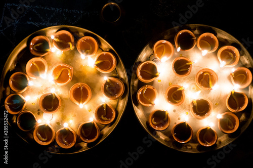 Macro shots of diyas being lit by hand or candle for the hindu religious festival of Diwali.