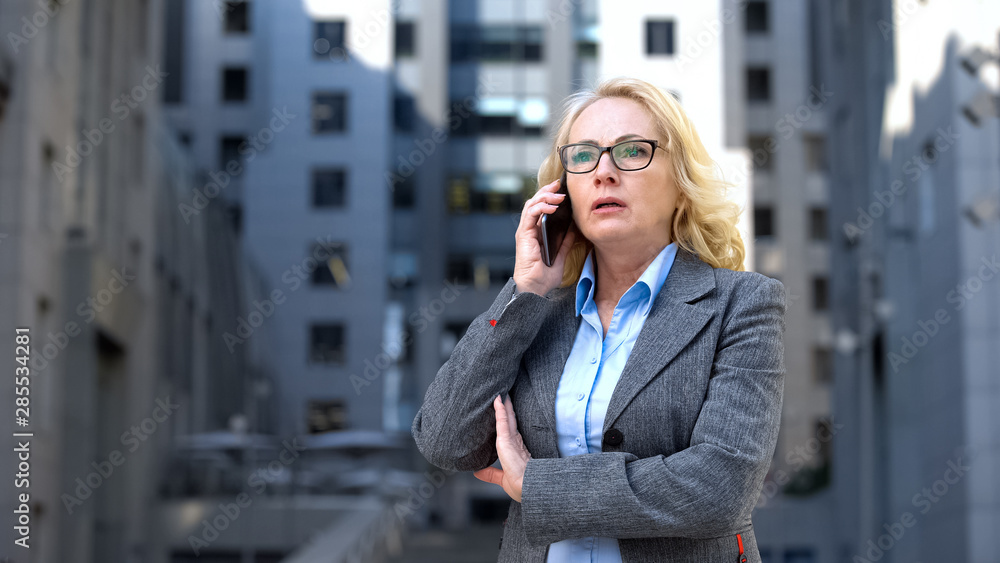 Shocked business woman talking phone outdoors office, bad news, work failure