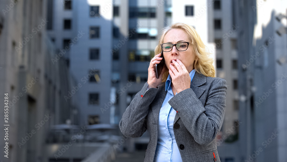 Disappointed aged manager holding smartphone standing outdoor office, tiredness Disappointed aged manager holding smartphone standing outdoor office, tiredness