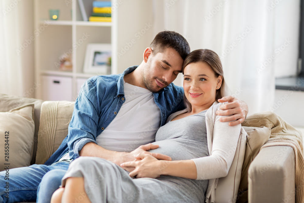 pregnancy and people concept - happy man hugging pregnant woman at home pregnancy and people concept - happy man hugging pregnant woman at home