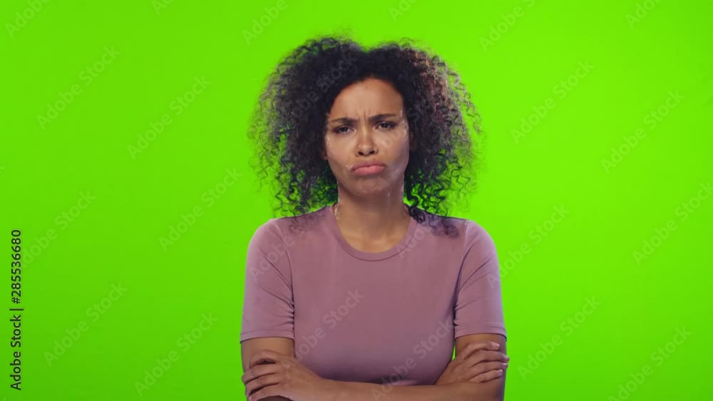 Displeased curly young African American woman in t-shirt with crossed ...