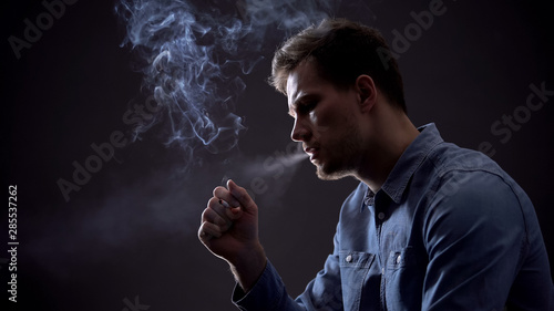 Upset man exhaling smoke, harmful unhealthy habit concept, tobacco industry