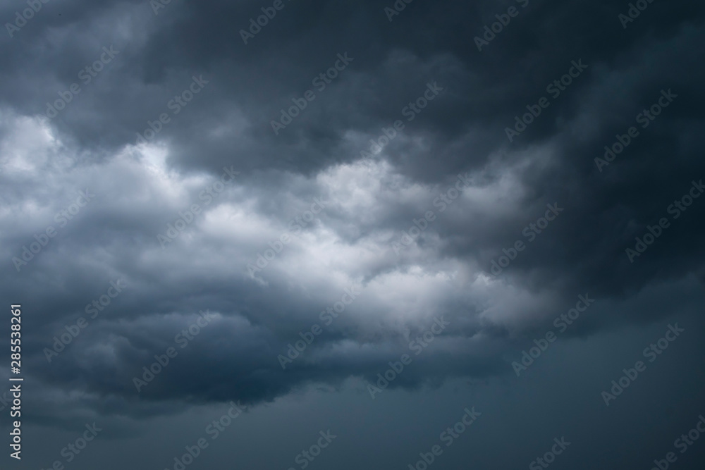 Dark thunder clouds on the blue sky. Abstract background with clouds on blue sky.