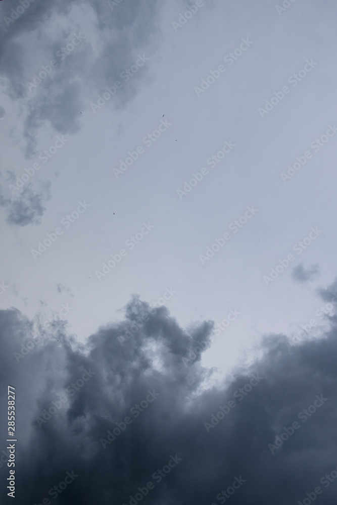 Fototapeta premium Dark thunder clouds on the blue sky. Abstract background with clouds on blue sky.