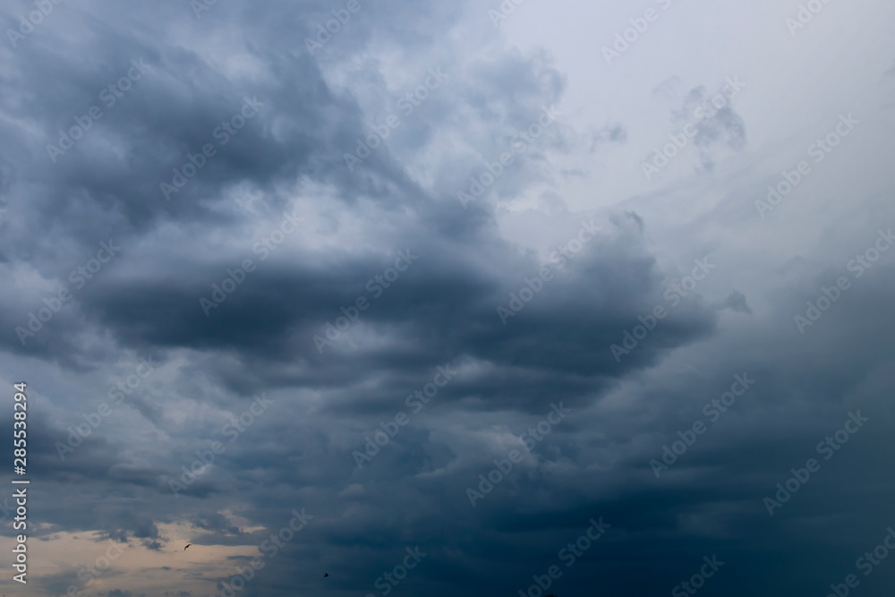 Dark thunder clouds on the blue sky. Abstract background with clouds on blue sky.