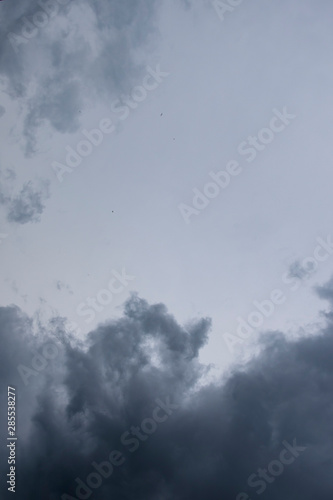 Dark thunder clouds on the blue sky. Abstract background with clouds on blue sky.