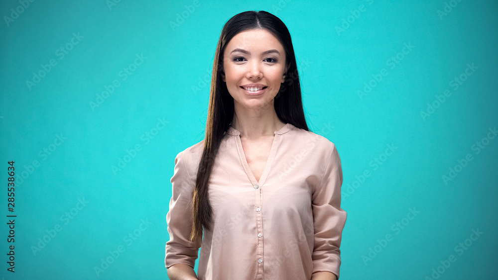 Fototapeta premium Friendly businesswoman smiling and looking at camera isolated on blue background