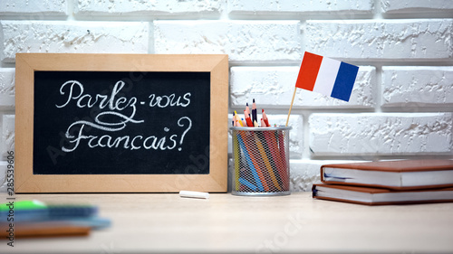 Do you speak French written on board, France flag standing in box, language photo