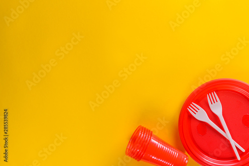 Red plastic dishes on a yellow background.