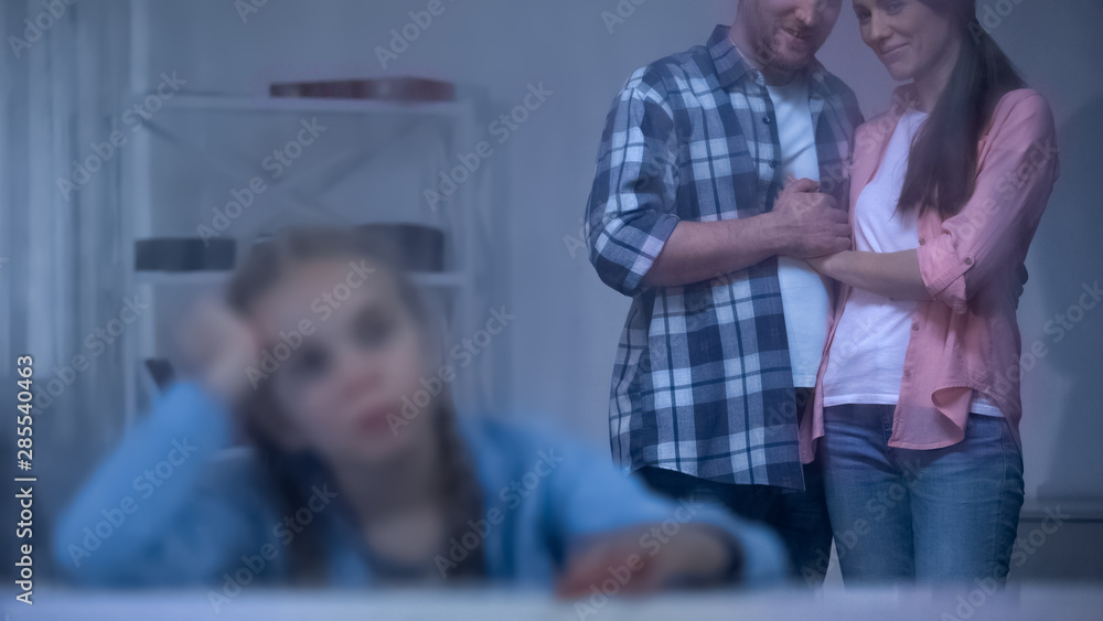 Obraz premium Sad orphan kid near rainy window, foster parents taking girl from orphanage