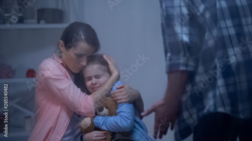 Принти на полотні Mother hugging daughter, protecting from angry father, harassment in family