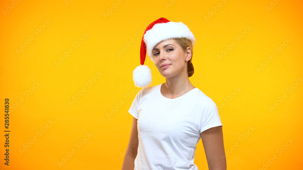 Flirty female in santa claus hat posing on camera, holiday celebration, party Flirty female in santa claus hat posing on camera, holiday celebration, party