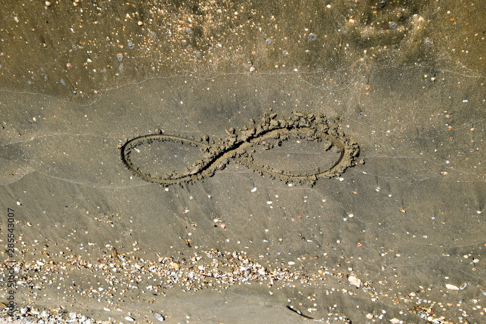 The sign of infinity on the sea. Coastal sand on the beach. The symbol of infinity The sign of infinity on the sea. Coastal sand on the beach. The symbol of infinity