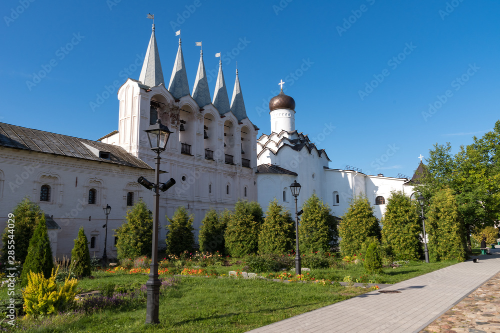 Fototapeta premium The belfry and the Church of the Protection of the Holy Virgin in Tikhvin Assumption (Assumption) monastery. Tikhvin, Russia