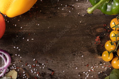 Vegetables decorated with vegetables on a beautiful old wooden table decorated with salt and pepper. Free space for your logo or text. Top view photo